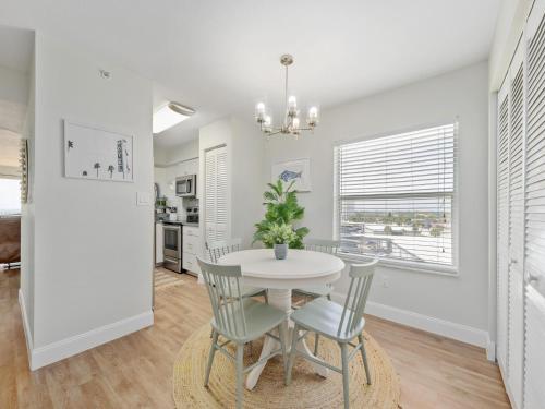 a dining room with a white table and chairs at Sea Winds 501 - Corner Breeze in Ormond Beach