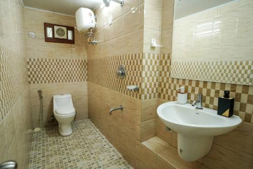 a bathroom with a sink and a toilet at Wayanad Palm Grove Retreat 1st Floor in Wayanad