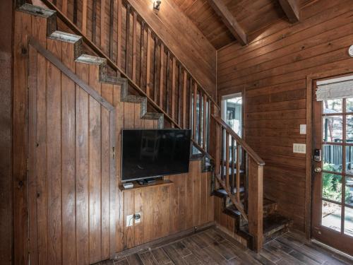 a living room with wooden walls and a flat screen tv at Midtown Riverfront 2 in Ruidoso