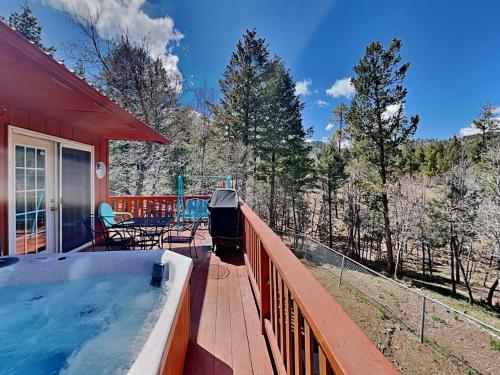 a hot tub on the deck of a red house at Touch of Santa Fe in Ruidoso