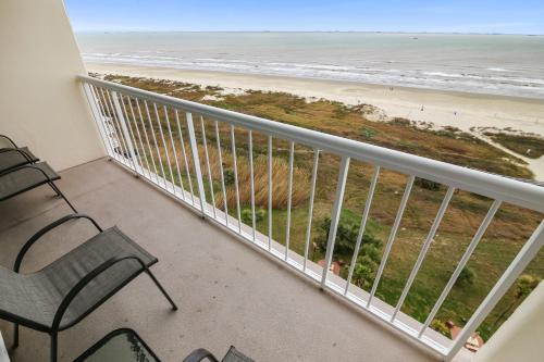 a balcony with a chair and a view of the beach at Galvestonian 1002-Beachfront Getaway in Galveston