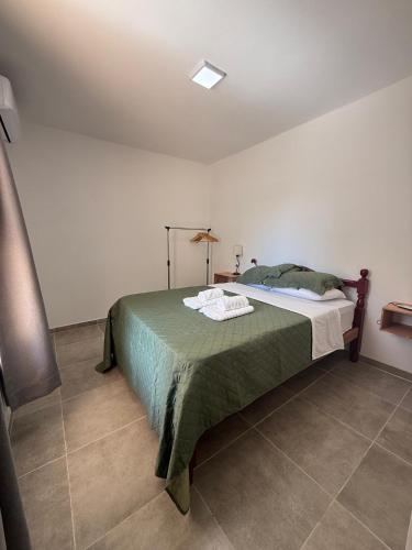 a bedroom with a bed with a green comforter at Don Sánchez in Cafayate