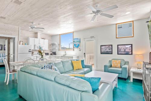 a living room with a blue couch and a kitchen at Above & Beyond in Port Aransas