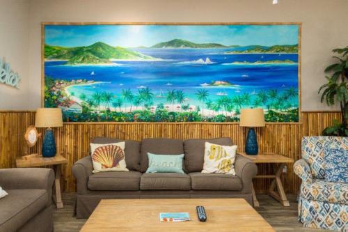 a living room with a large painting of a beach at Lets Padre at Village by the Beach in Padre Island