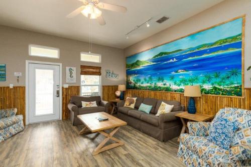 a living room with couches and a painting on the wall at Lets Padre at Village by the Beach in Padre Island