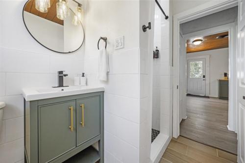 a bathroom with a sink and a mirror at Whispering Oak- Lakefront Cabin Retreat in Madill
