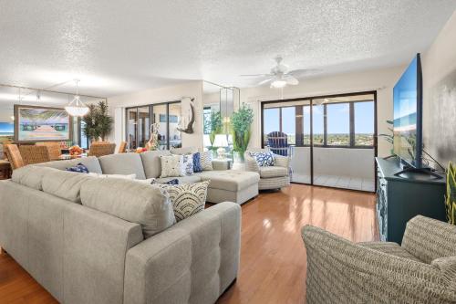 a living room with couches and a flat screen tv at Oceanfront Penthouse 11b in Ormond Beach