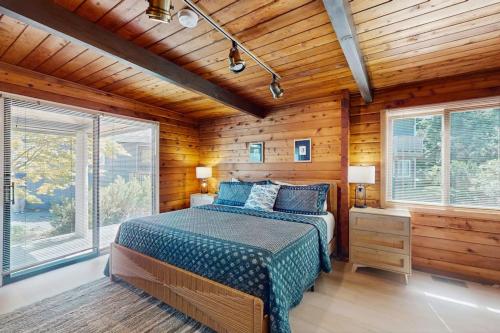 a bedroom with a bed in a room with wooden walls at Sea Side Cedar in Langley