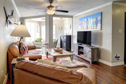 a living room with a couch and a tv at Sand In Your Toes in Mustang Beach