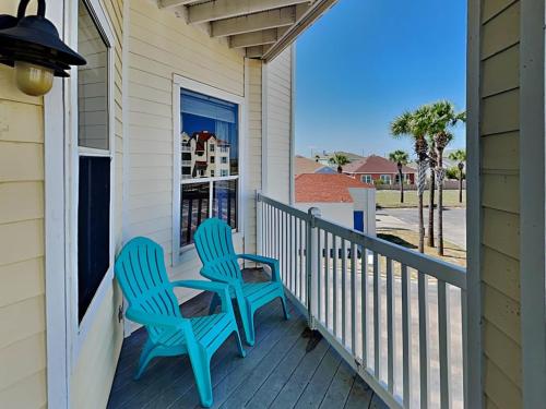 two blue chairs sitting on the porch of a house at Toes In The Water II in Padre Island