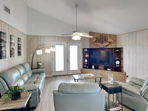 a living room with couches and a flat screen tv at Seagulls Landing in Galveston