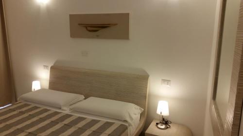 a small bedroom with a bed with two white pillows at La casa di Pier in Olbia