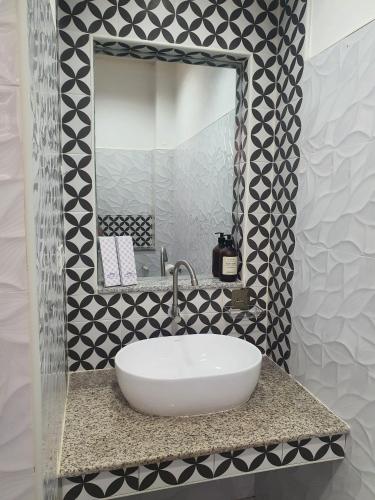 a bathroom with a white sink and a mirror at JG Privspace in San Juan