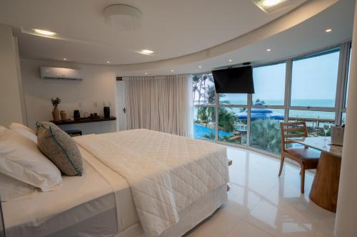 a bedroom with a bed and a view of the ocean at Mansao in Maragogi