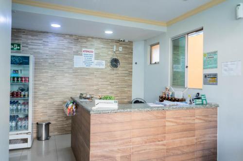 a kitchen with a counter with a sink and a refrigerator at Hotel Oliveira in Goiânia