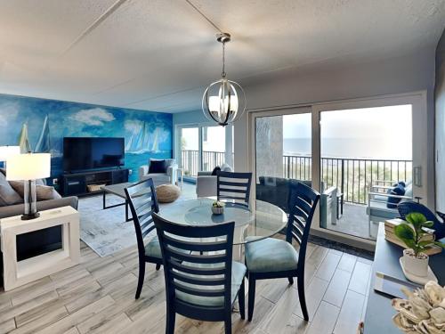 a living room with a table and chairs and a television at Beachcomber 403 in Jacksonville Beach