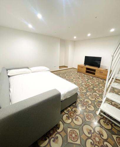 a bedroom with a bed and a flat screen tv at Apuliantales Cottage Bari in Carbonara di Bari