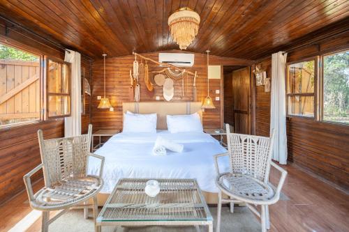 a bedroom with a bed with two chairs and a table at Maison Lakala in Ben Slimane