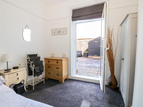 a bedroom with a door open to a patio at Northgate Ground Floor Flat in Hunstanton