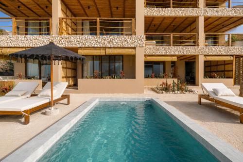 a swimming pool in front of a house at Luxury Villas By Awa Holbox - Beachfront in Holbox Island