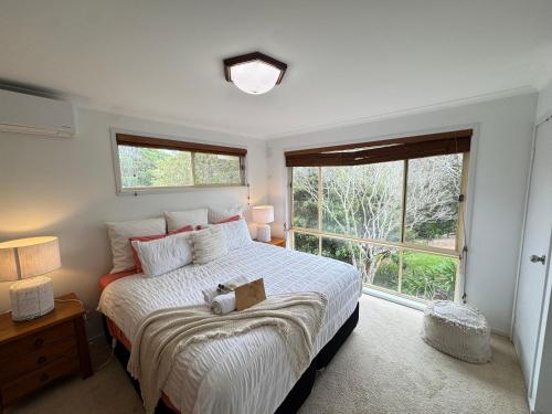 a bedroom with a large bed with a large window at Palacete Beach - Resort Style Stay in Culburra Beach