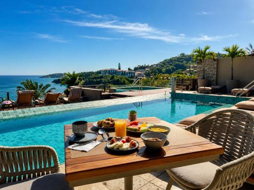 a table with food on it next to a swimming pool at HOTEL VILLE LA PLAGE & BEACH CLUB in Búzios