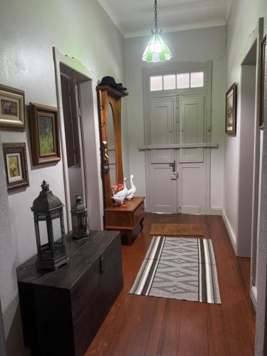 a living room with a door and a rug at Casa da Praça Hospedaria in Tibagi
