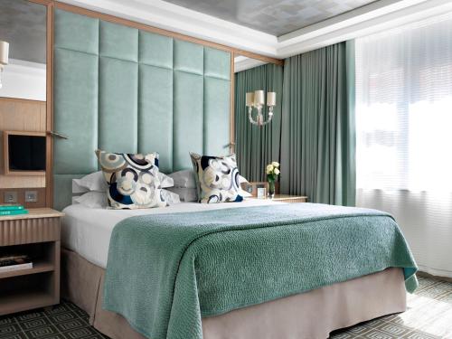a bedroom with a bed with a green wall at The Marylebone Hotel in London