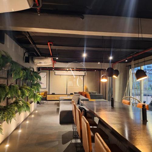 a bar in a room with a long table at RioDowntown Hub by RNC Flats in Rio de Janeiro