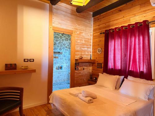 a bedroom with a bed with a red window at Rahoni Park & Apartments in Dhërmi