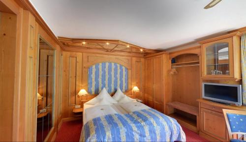 a bedroom with a bed and a tv in it at Hotel Augsburger Hof in Augsburg