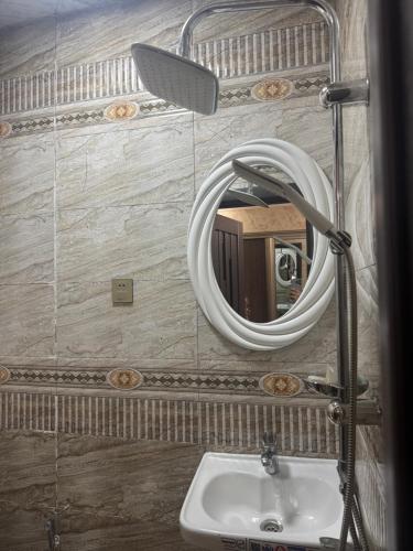a bathroom with a mirror and a sink at Northern City Hotel in Zaqatala