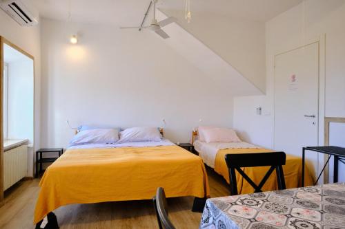 two beds in a room with yellow sheets at Il Brigantino in Cori