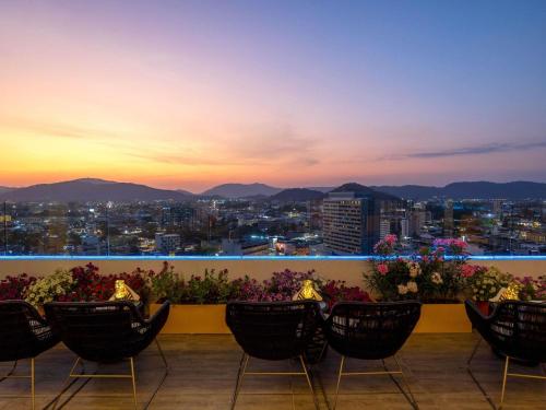 a balcony with chairs and a view of a city at Novotel Phuket City Phokeethra in Phuket