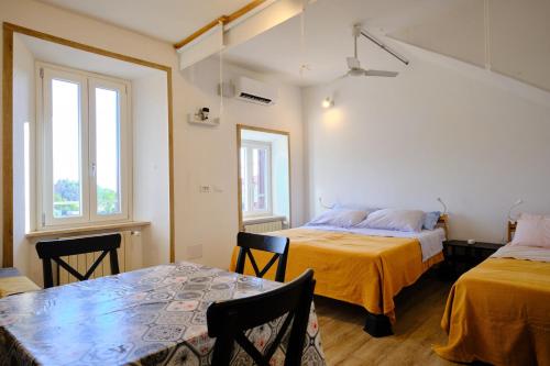 a room with two beds and a table and chairs at Il Brigantino in Cori