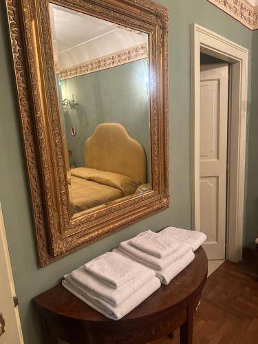 a mirror with a pile of towels on a table at B&B La Porticella in Viterbo