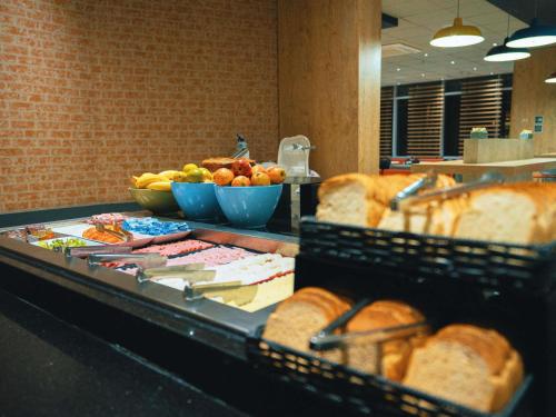 a counter with bread and bowls of fruit and vegetables at ibis Sao Bernardo do Campo in São Bernardo do Campo