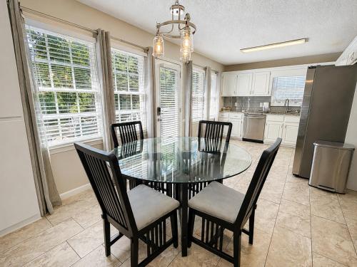 a dining room with a glass table and chairs at Embrace The Outdoors In This Modern Rydal Setting in White