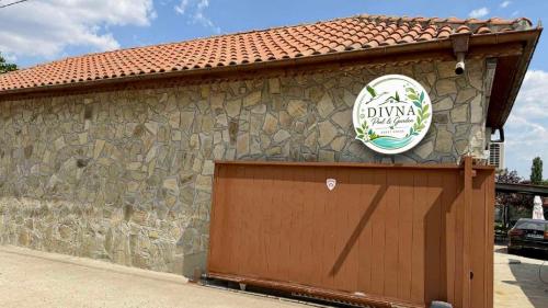 a building with a garage with a sign on it at Divna Pool&Garden 