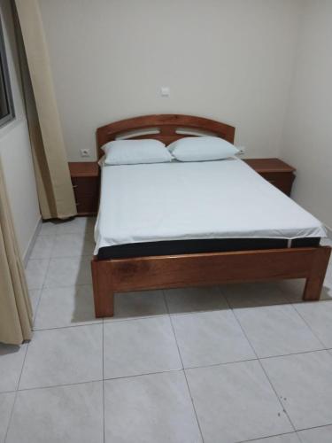 a bedroom with a bed with white sheets on it at Salão Zuzu in Ribeira Grande