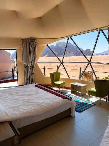 a bedroom with a bed and a view of the desert at Wadi Rum Panorama Suites in Disah