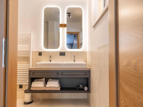 a bathroom with a sink and a mirror at Dachstein Grand Alpine Lodge in Mitterberg-Schladming-Dachstein
