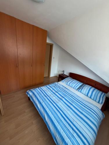a bedroom with a bed with a blue striped blanket at Donovaly apartmán 33 in Donovaly