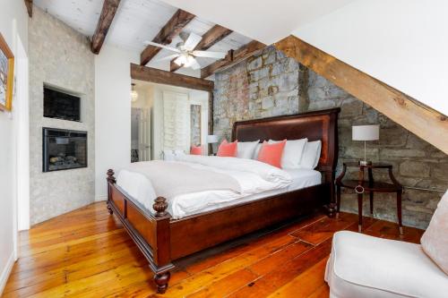 a bedroom with a bed and a stone wall at All Suites Whitney Manor in Kingston