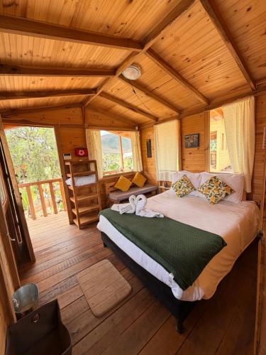a bedroom with a bed in a wooden cabin at Glamping Entre Nopales - Sáchica cerca a Villa de Leyva in Sáchica
