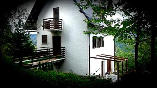 una casa bianca con un balcone sul lato di Holiday Home Lipa a Vrbovsko