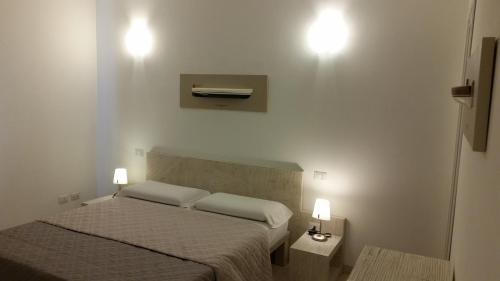 a bedroom with two beds and two lights on the wall at La casa di Pier in Olbia