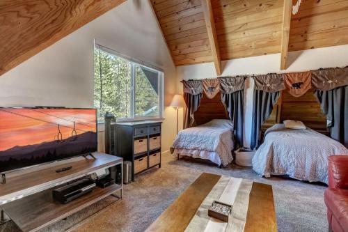 a bedroom with two beds and a flat screen tv at Panorama Chalet in Nebelhorn
