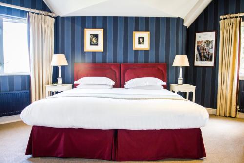 een groot bed met een rood hoofdeinde in een slaapkamer bij Leander Club in Henley on Thames