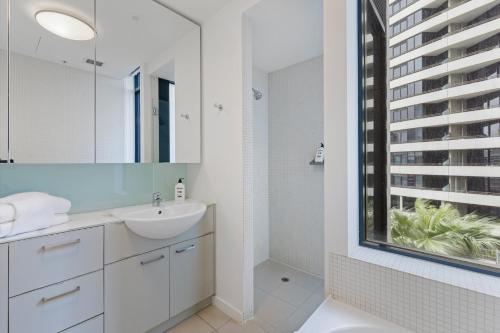 a white bathroom with a sink and a mirror at The Sebel Residences Melbourne Docklands Serviced Apartments in Melbourne